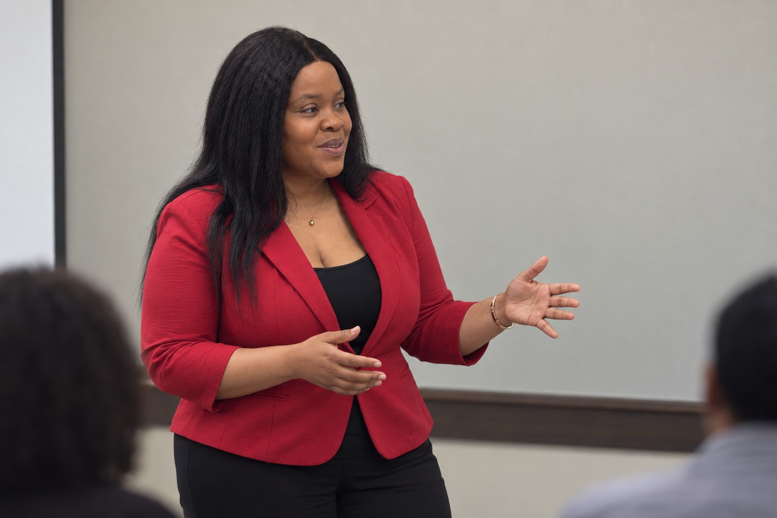 Natacha Alcindor standing and speaking to a seated audience